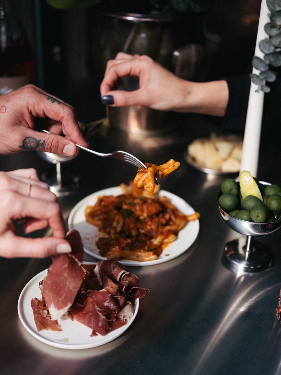 Hands sharing food and drinks at the FRONT bar